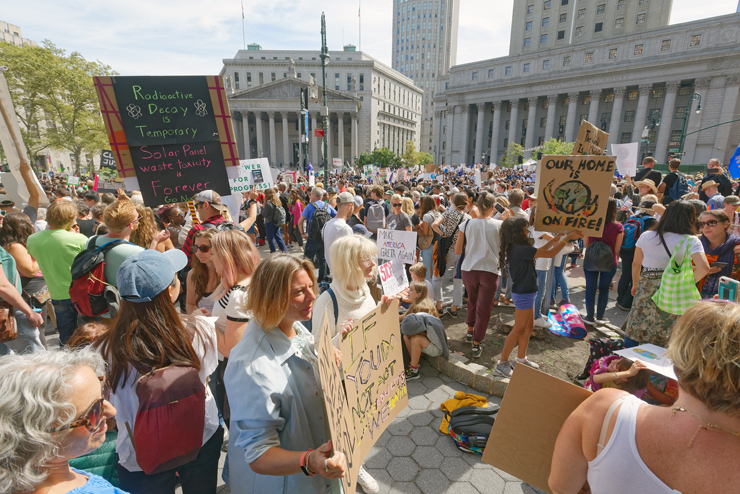 Top: It would be more than an hour before a tired Nile and others outside the Federal Building would be able to begin marching. Above: Mother and daughter begin the slow move out of the plaza. Photos: Carl Glassman/Tribeca Trib